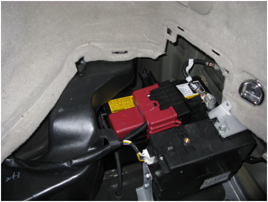 Prius 12V Battery - Located in RH Rear Corner of Vehicle. Note Red Plastic Cover Over The &ldquo;+&rdquo; Battery Terminal
